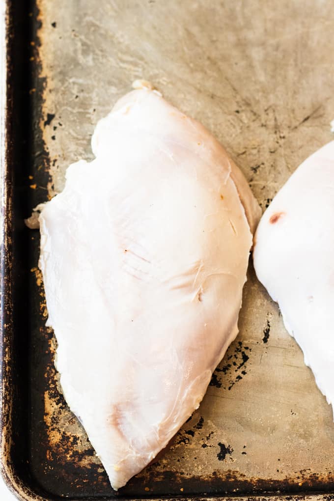 Turkey breasts removed from the turkey on a baking sheet ready to be smoked. 