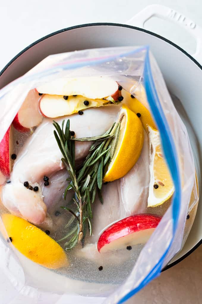 Turkey breast in a large plastic bag with the brine, lemon slices, apples, and sprigs of rosemary. 