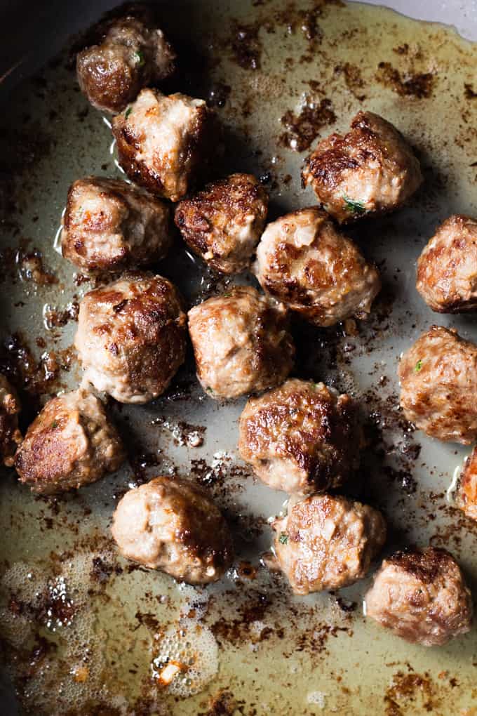 Swedish meatballs seared in a large skillet.