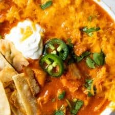 Close up of a bowl of chicken tortilla soup with all the toppings.