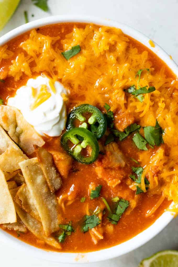 Close up of a bowl of chicken tortilla soup with all the toppings. 
