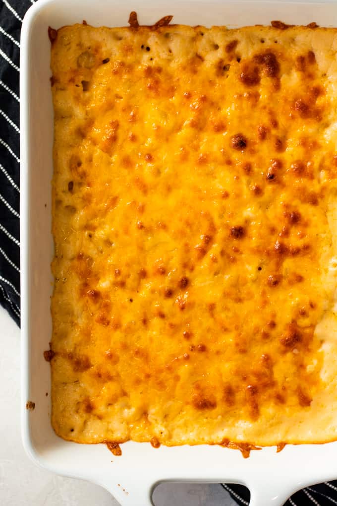 Baking dish filled with baked macaroni and cheese, showing browned bits of cheese on the top layer.