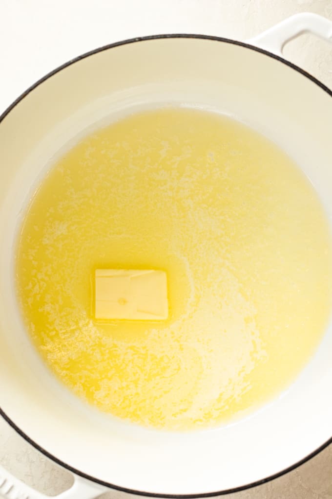 Butter melting in a large dutch oven pot for making homemade cheese sauce for macaroni and cheese.