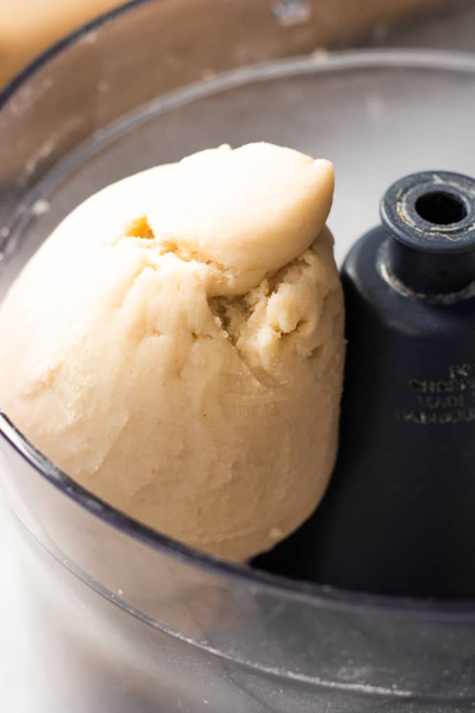 Ball of pie crust dough in a food processor.