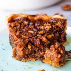 A slice of pecan pie on a dish.