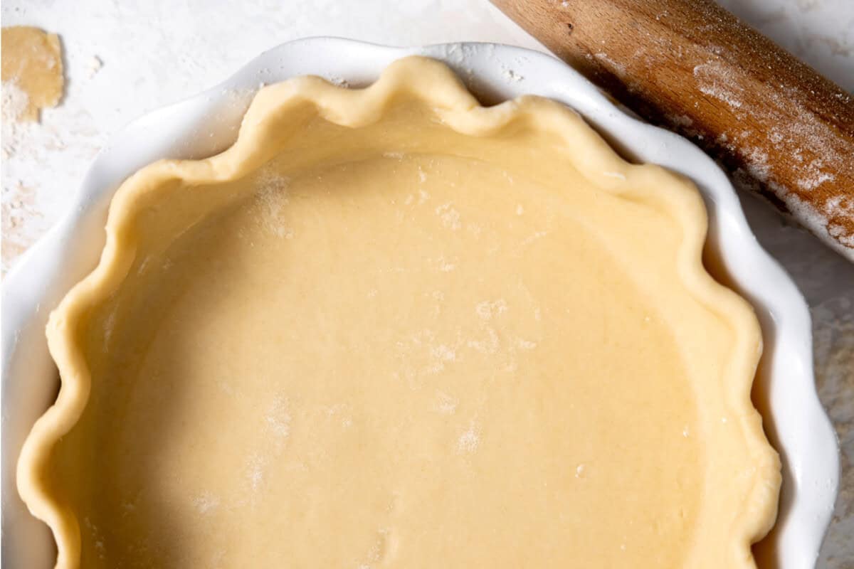 Beautifully fluted pie crust in a white ceramic pie dish. 