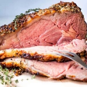 Slicing into a cooked prime rib that is rare in the center.