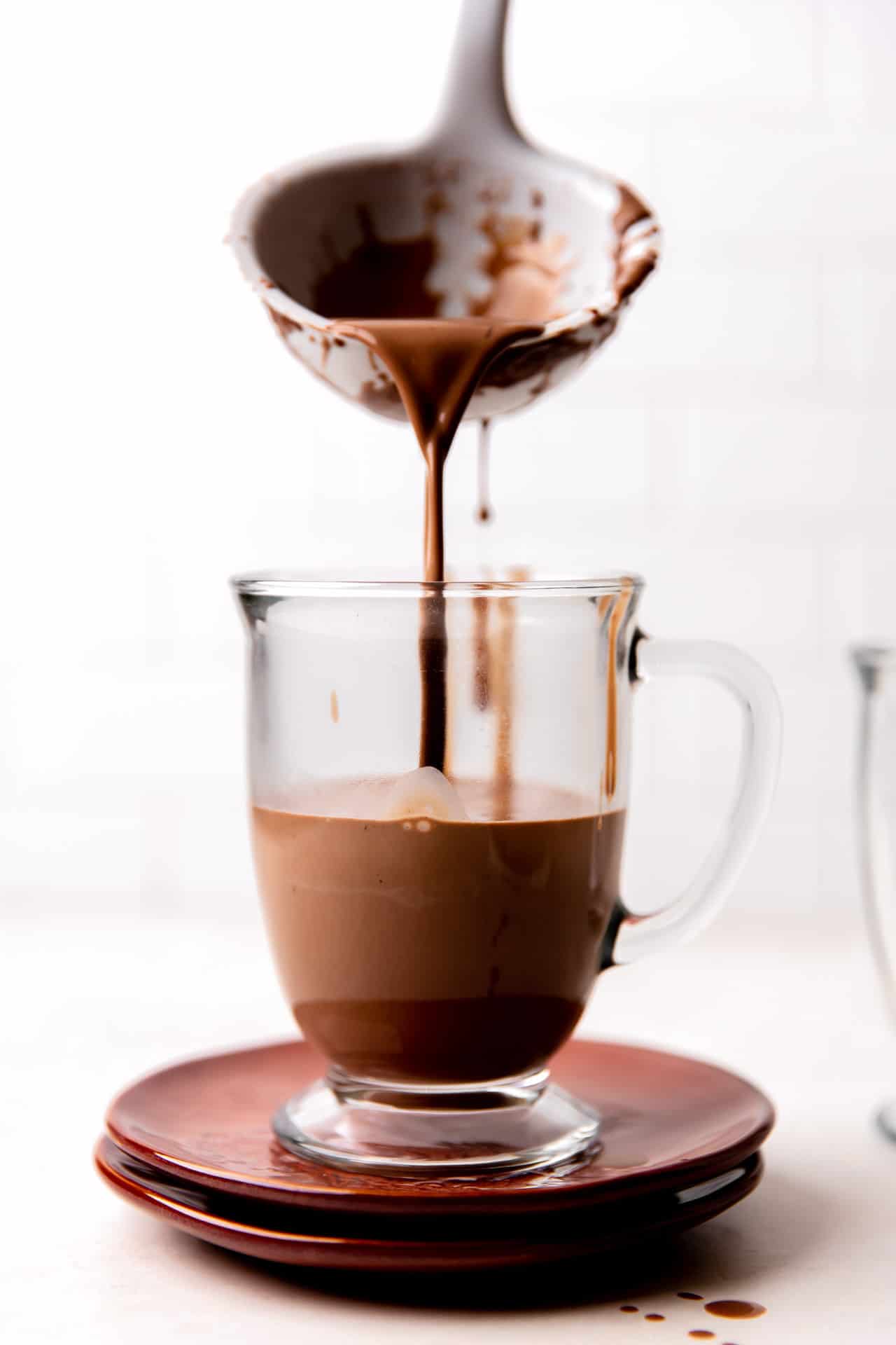 Ladle pouring hot chocolate into a mug.
