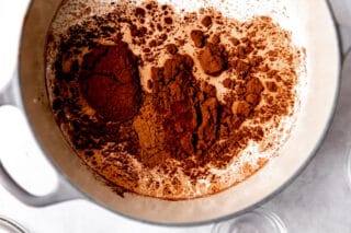 Milk, cocoa, cinnamon and chili powder in a pot for hot chocolate.