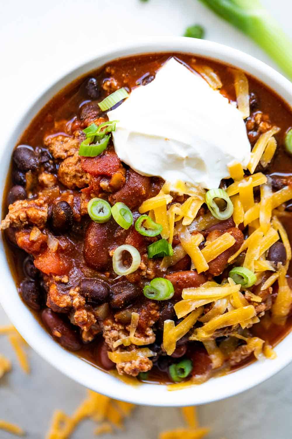 Bowl filled with turkey chili, topped with sour cream, onion and cheese. 