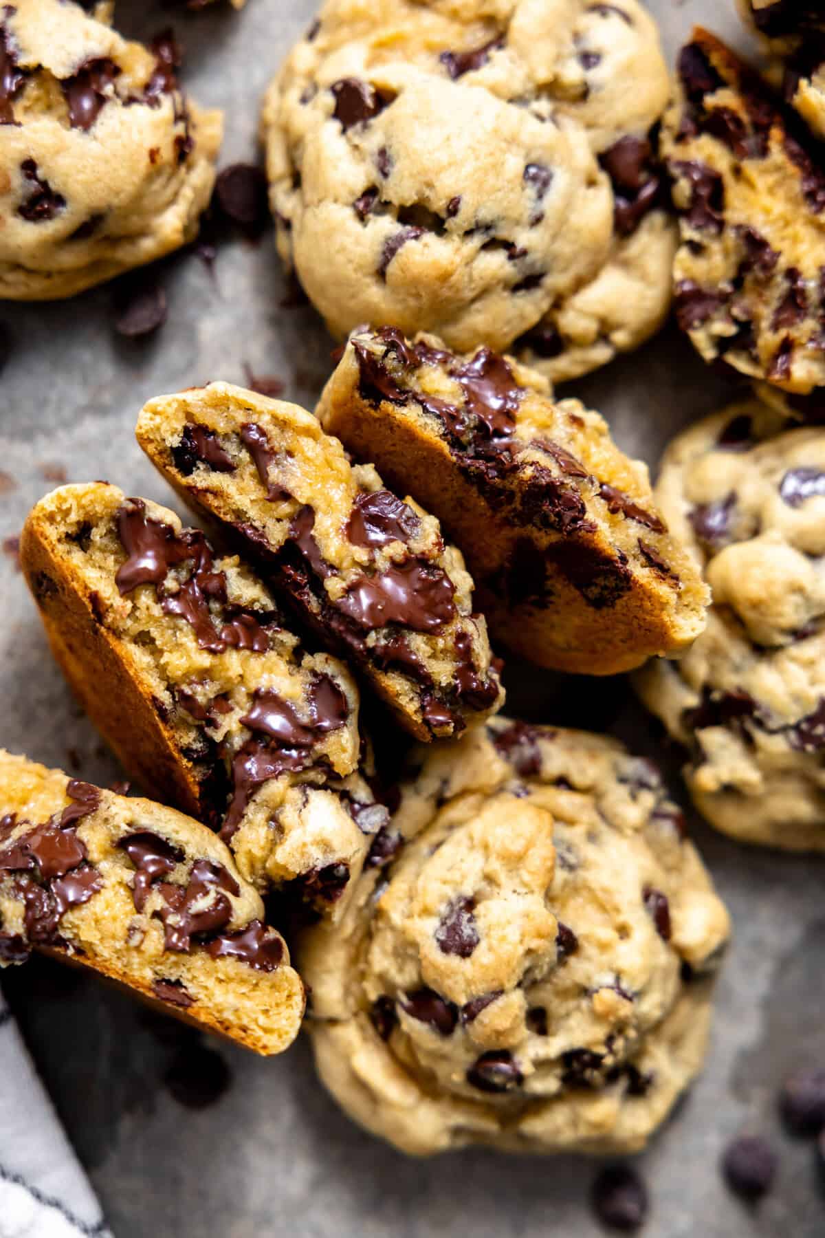 Thick chocolate chip cookies split in half and arranged on a cookie sheet. 