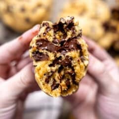 Thick chocolate chip cookie being split in half.