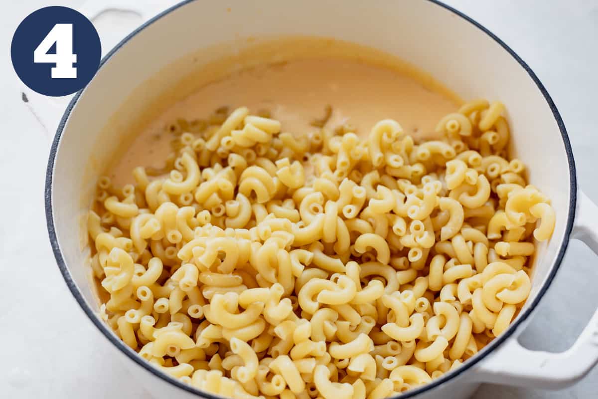 Stirring macaroni noodles into homemade cheese sauce.