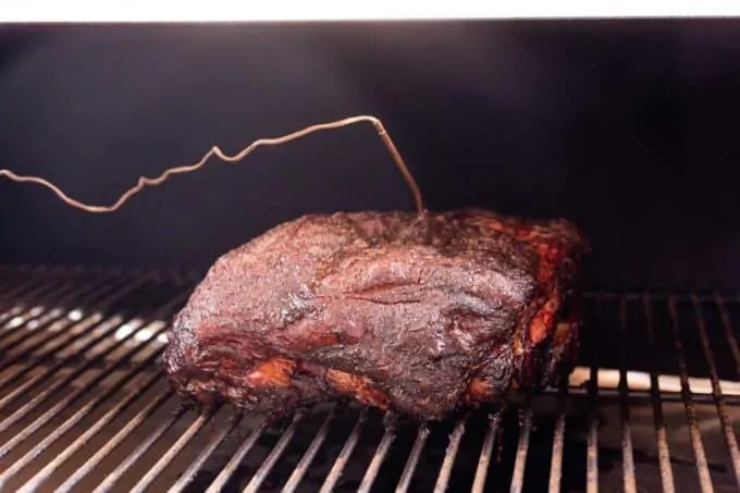 Pork Shoulder in a smoker with a temperature prob inserted.