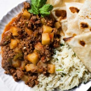 Overhead view of beef and potato picadillo served with cilantro lime rice and fresh flour tortillas.