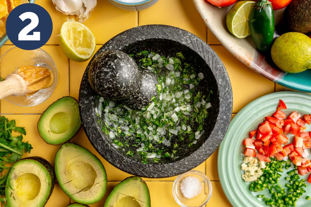 Grinding up onion and and cilantro in a molcajete. 