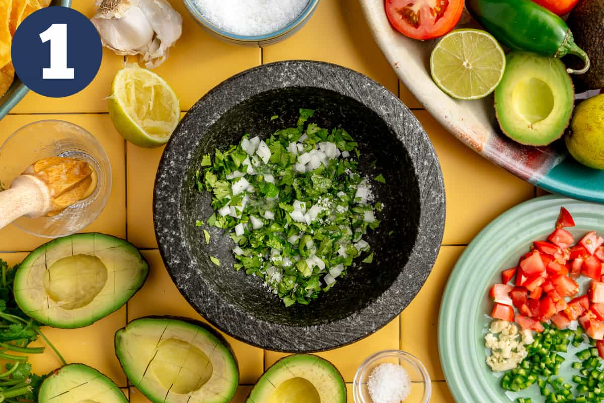 Molcajete with onion, cilantro and garlic that has lime juice on it. 