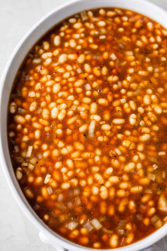 Beans in a sweet syrup in a white baking dish.