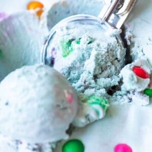An ice cream scoop scooping up light blue colored bubble gum ice cream.