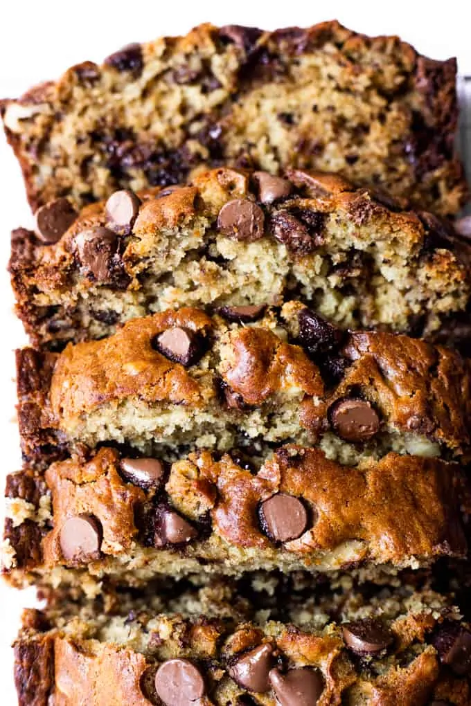 Overhead view of a loaf of banana bread with chocolate chips that has been sliced into thick slices.