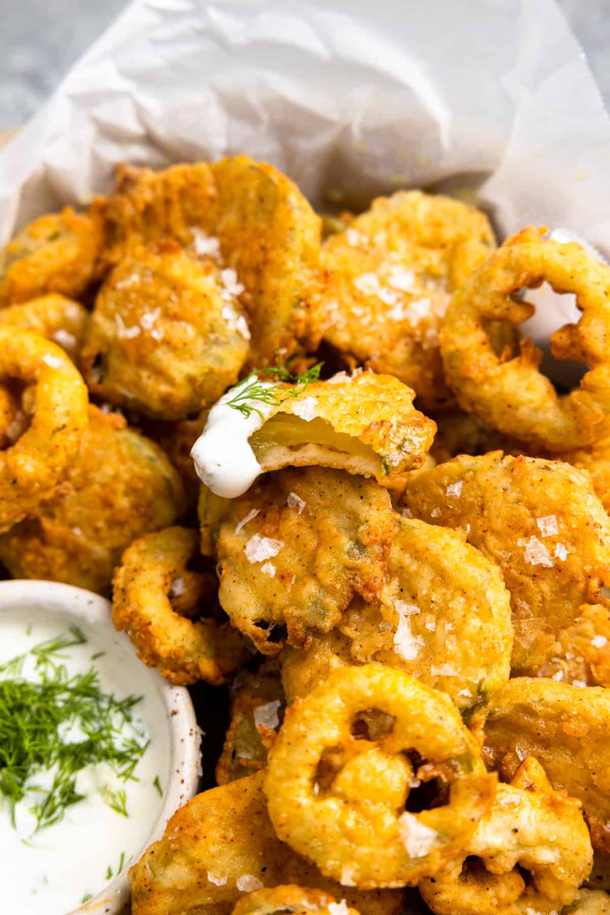 Basket of fried pickles served with fried jalapeños and a bowl of ranch dressing.