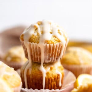 Lemon muffins stacked with glaze drizzling down the side.