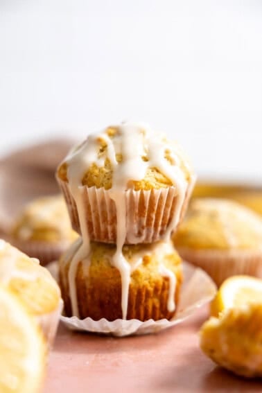 Lemon muffins stacked with glaze drizzling down the side.