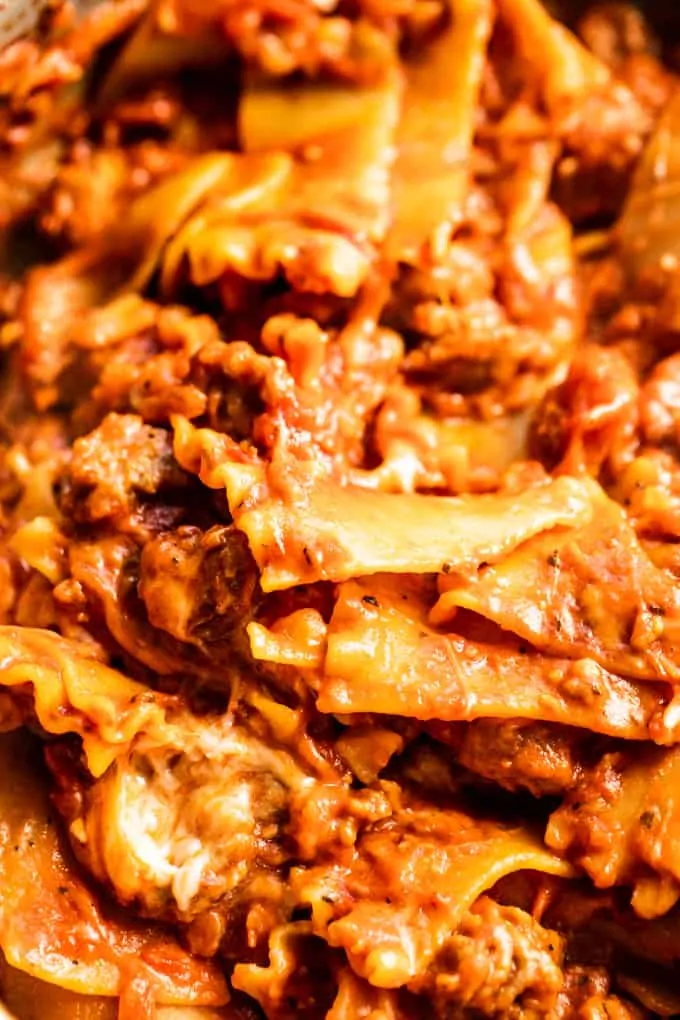 Up close look at lasagna noodles smothered in sauce and coated with melted cheese.