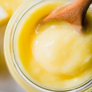 Overhead view of a glass jar filled with lemon curd, showing the smooth, creamy texture.