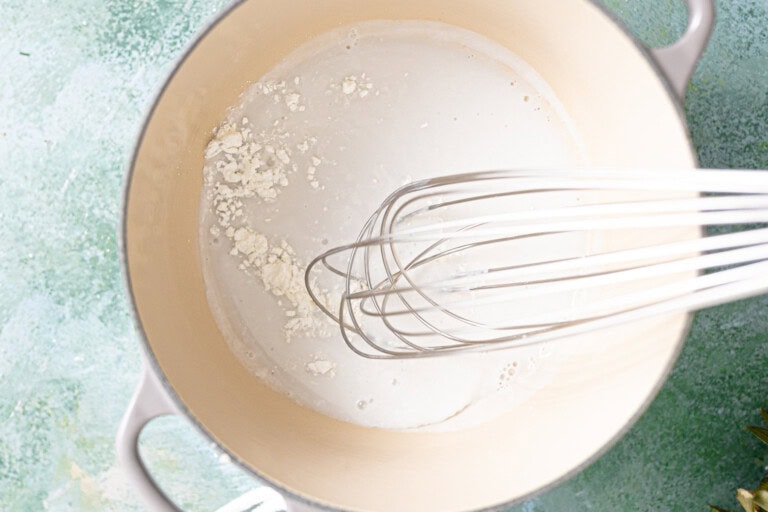 Coconut cream, milk, and rum in a saucepan to make a sauce.