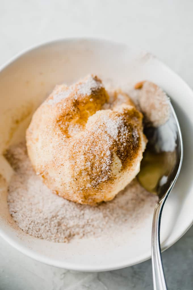 Scoop of ice cream being coated with a cinnamon sugar mixture.