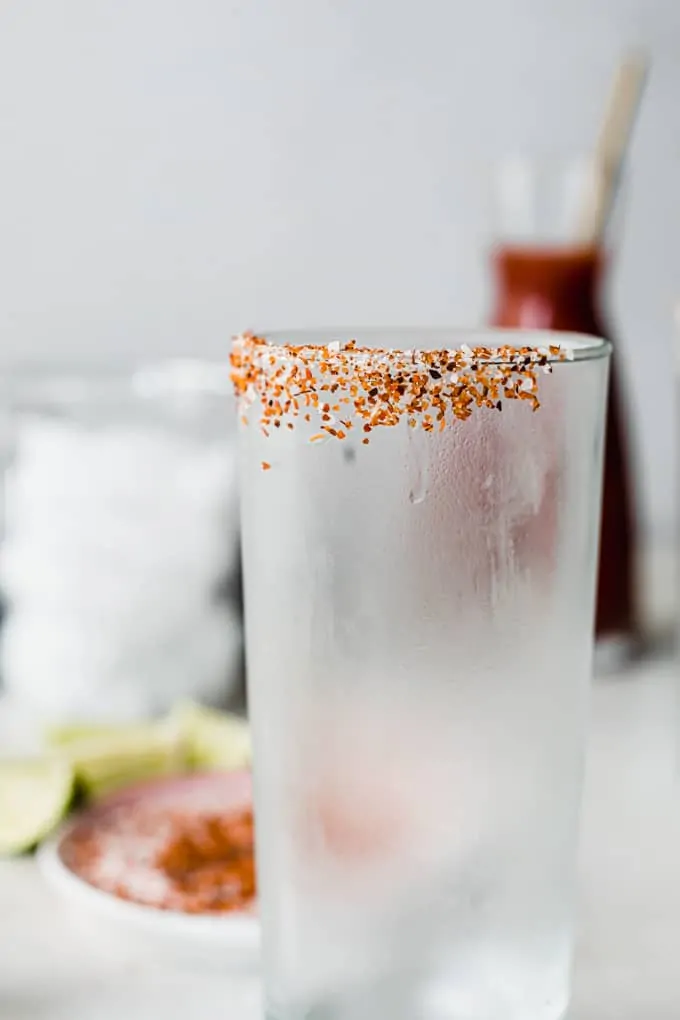 Frosty glass with a rim covered in salt and Tajin. 