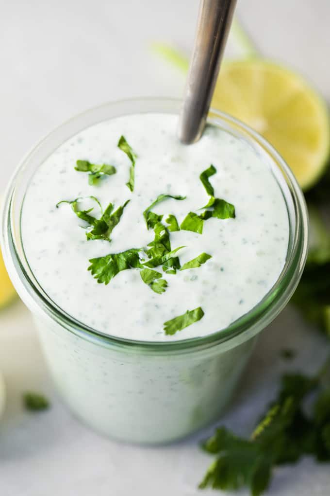 Glass jar filled with creamy Cilantro Lime Crema. 