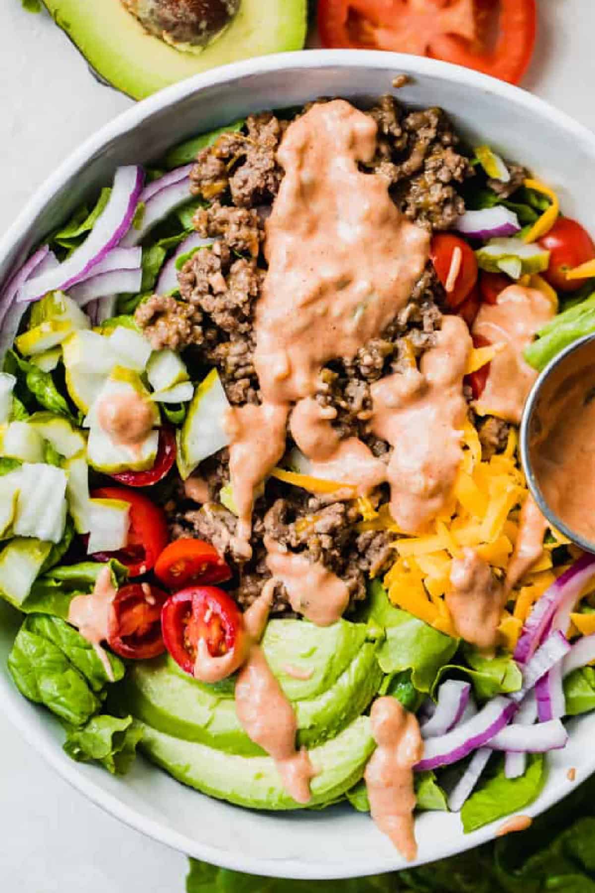 Burger bowl topped with homemade sauce in a white bowl.