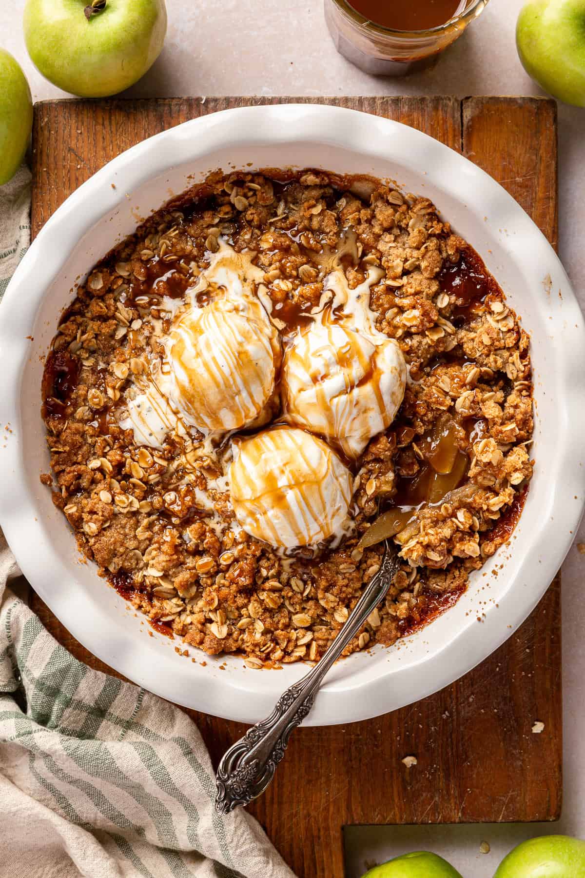 Scoops of ice cream on top of caramel apple crisp.