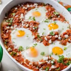 Huevos Rancheros breakfast casserole in a white casserole dish, topped with fresh diced cilantro.
