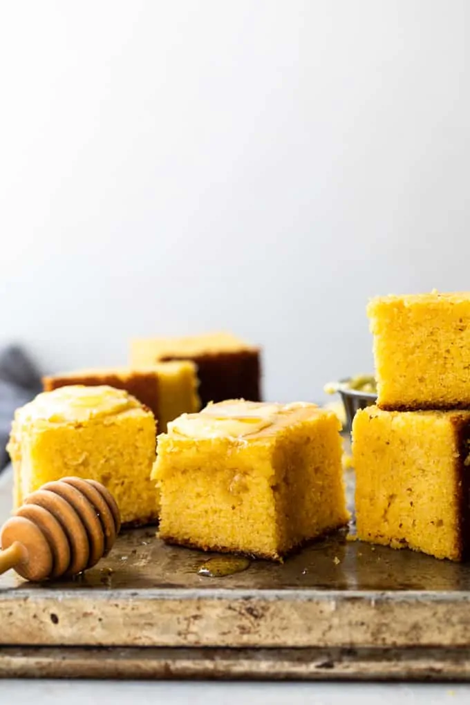Slice of cornbread served with honey soaking into the top. 