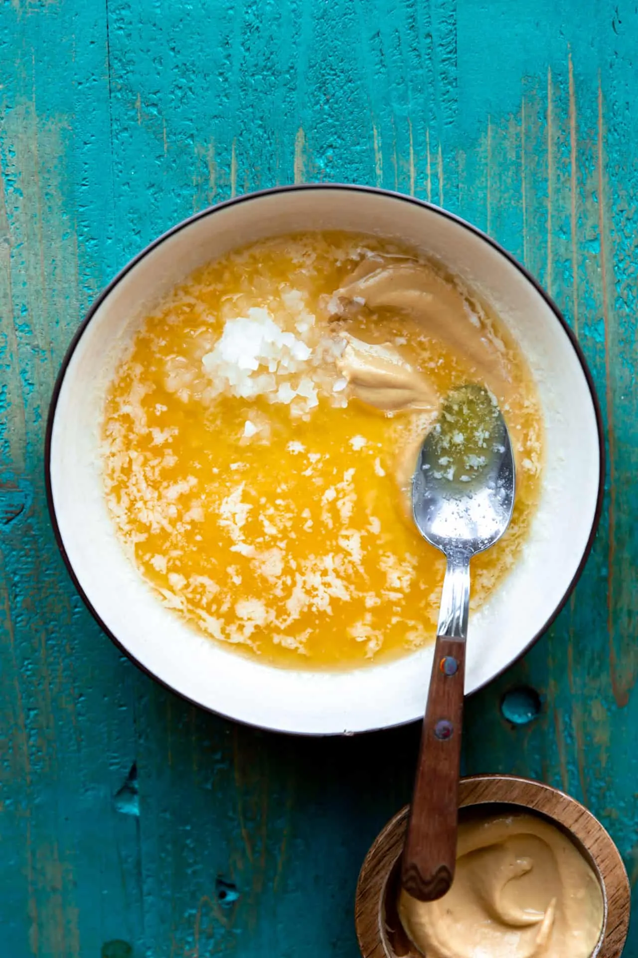 Bowl filled with ingredients needed to make a butter dijon sauce to pour on top of cuban sliders.