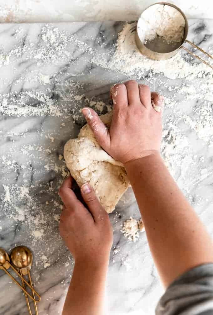 Overhead shot of hands kneading sopapilla dough.