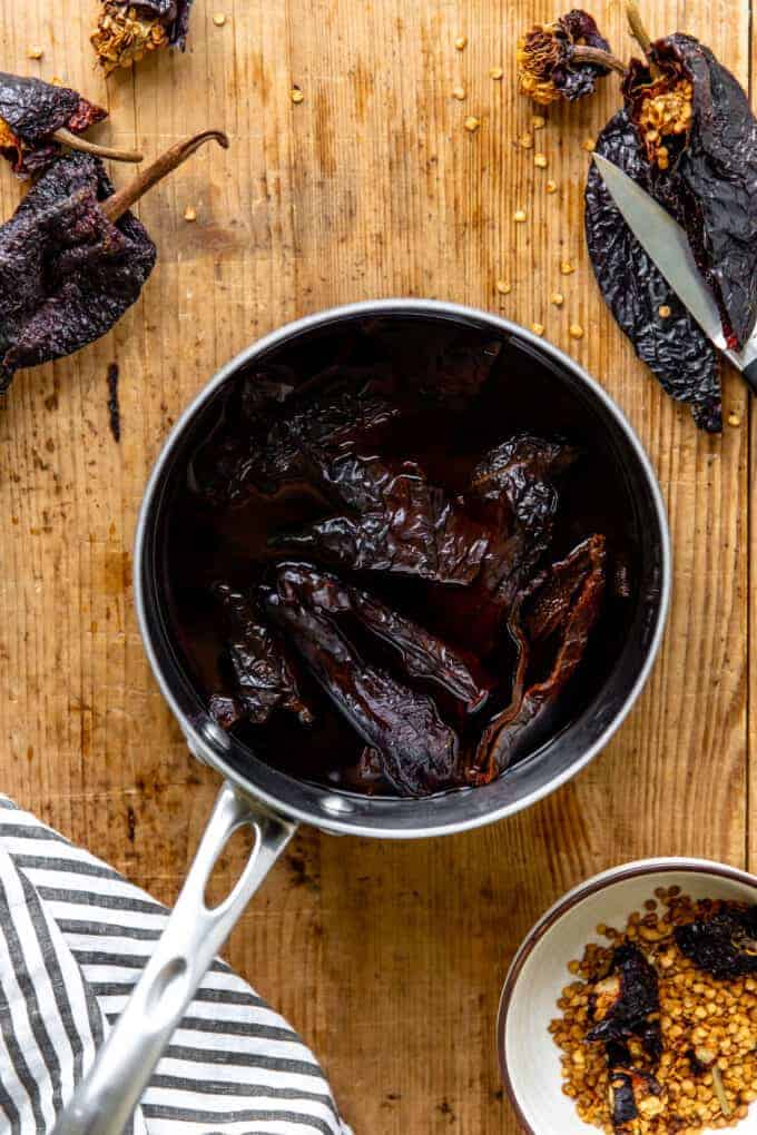 gedroogde chilis die zijn ontzaaid en geroosterd in water in een pan.