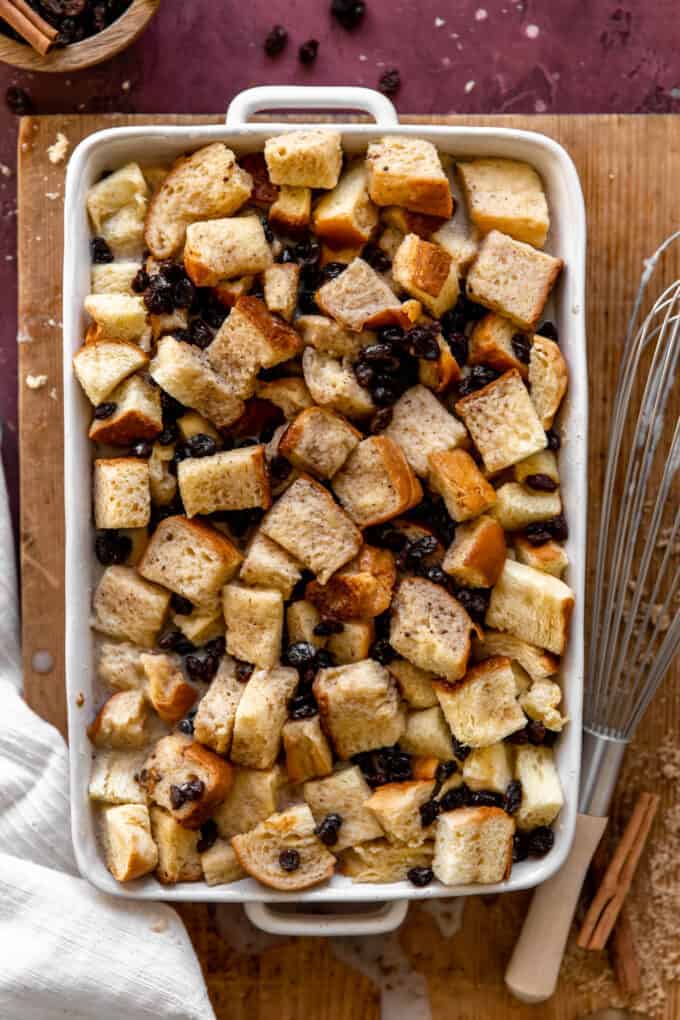 Baking dish filled with cubed bread and raisins to bake for bread pudding.