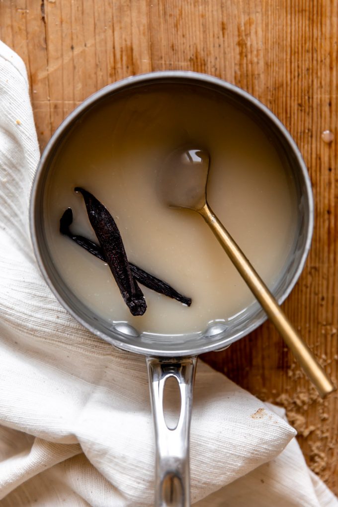 Homemade vanilla syrup in a saucepan for drizzling onto bread pudding.