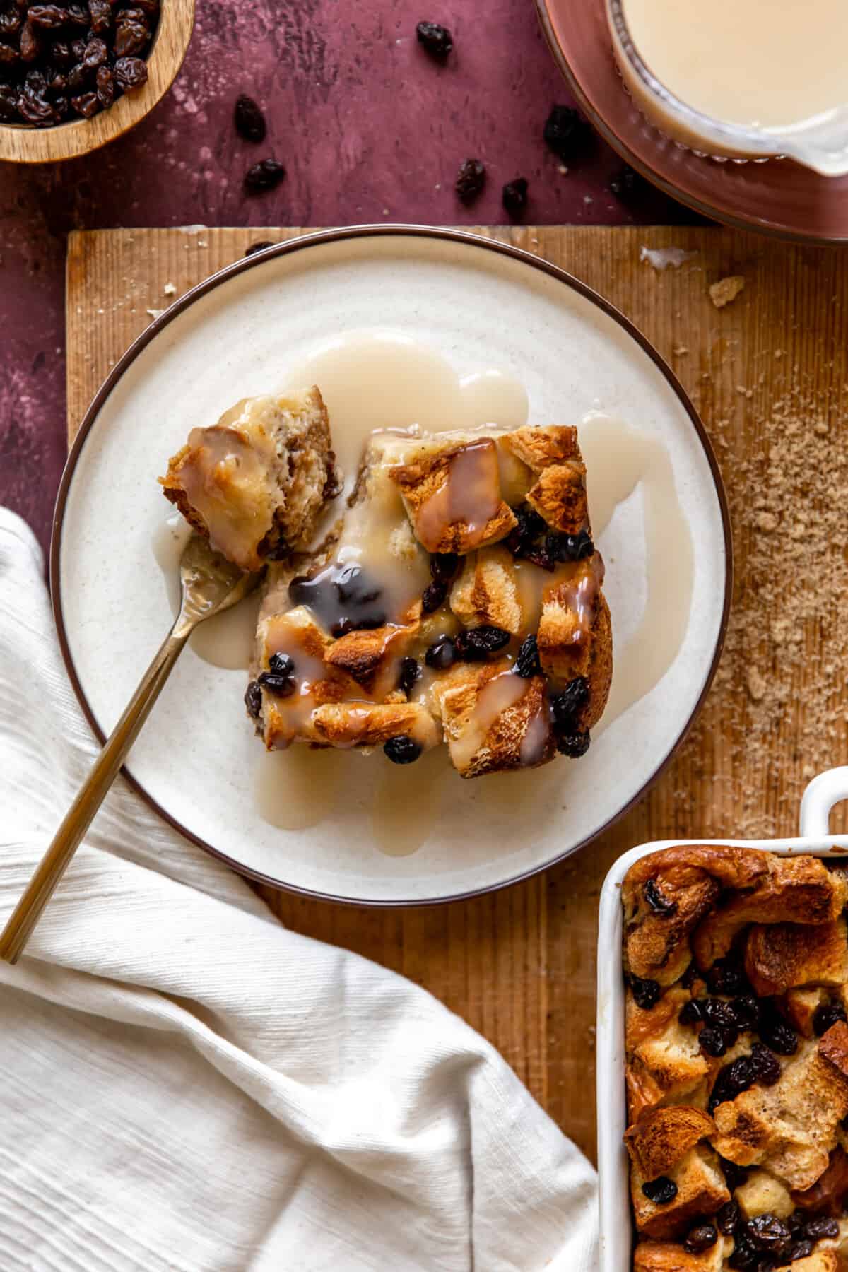 Slice of bread pudding served with vanilla syrup drizzled over top. 