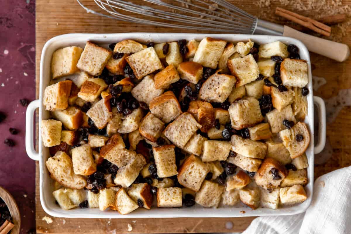 Baking dish with cubed dried bread and raisins for bread pudding.