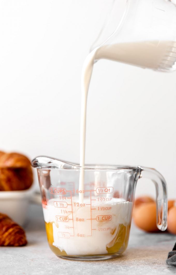 Milk being added to a measuring cup with eggs for the custard portion of the breakfast casserole.