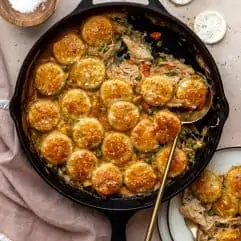 Cast iron skillet filled with pot pie filling and topped with golden circles of pastry.