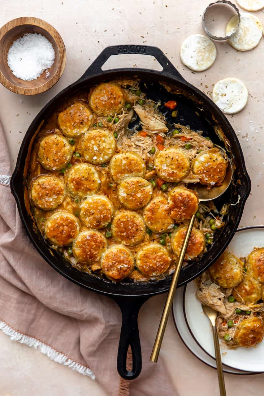 Cast iron skillet filled with pot pie filling and topped with golden circles of pastry. 