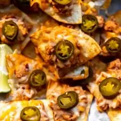 Texas Nachos made with refried beans, cheese and jalapeno on a tray to be served.