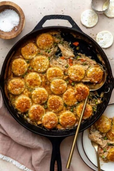 Cast iron skillet filled with pot pie filling and topped with golden circles of pastry.