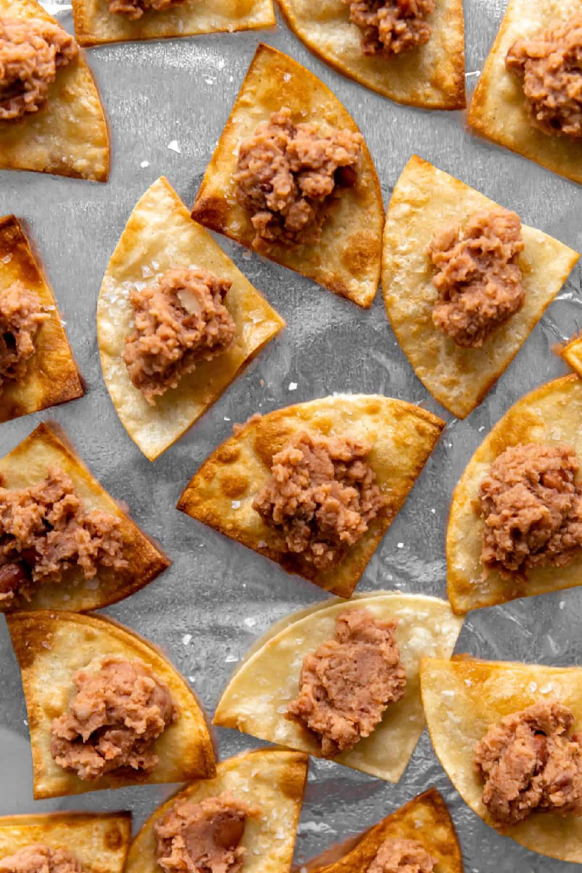 Tortilla chips topped with refried beans.